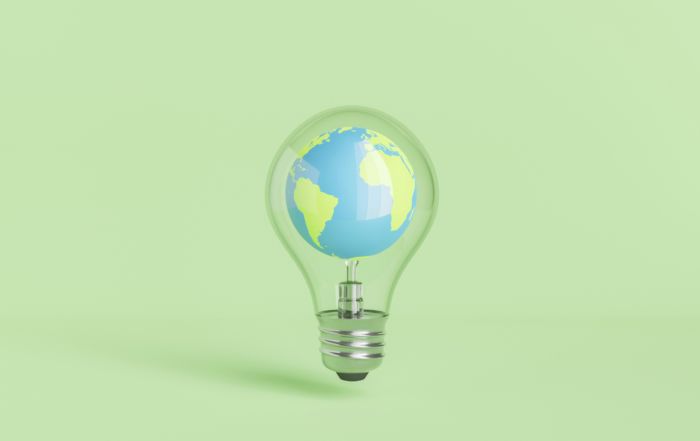 Globus in Glühbirne vor grünem Hintergrund