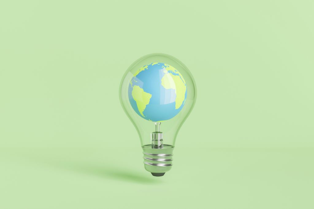 Globus in Glühbirne vor grünem Hintergrund